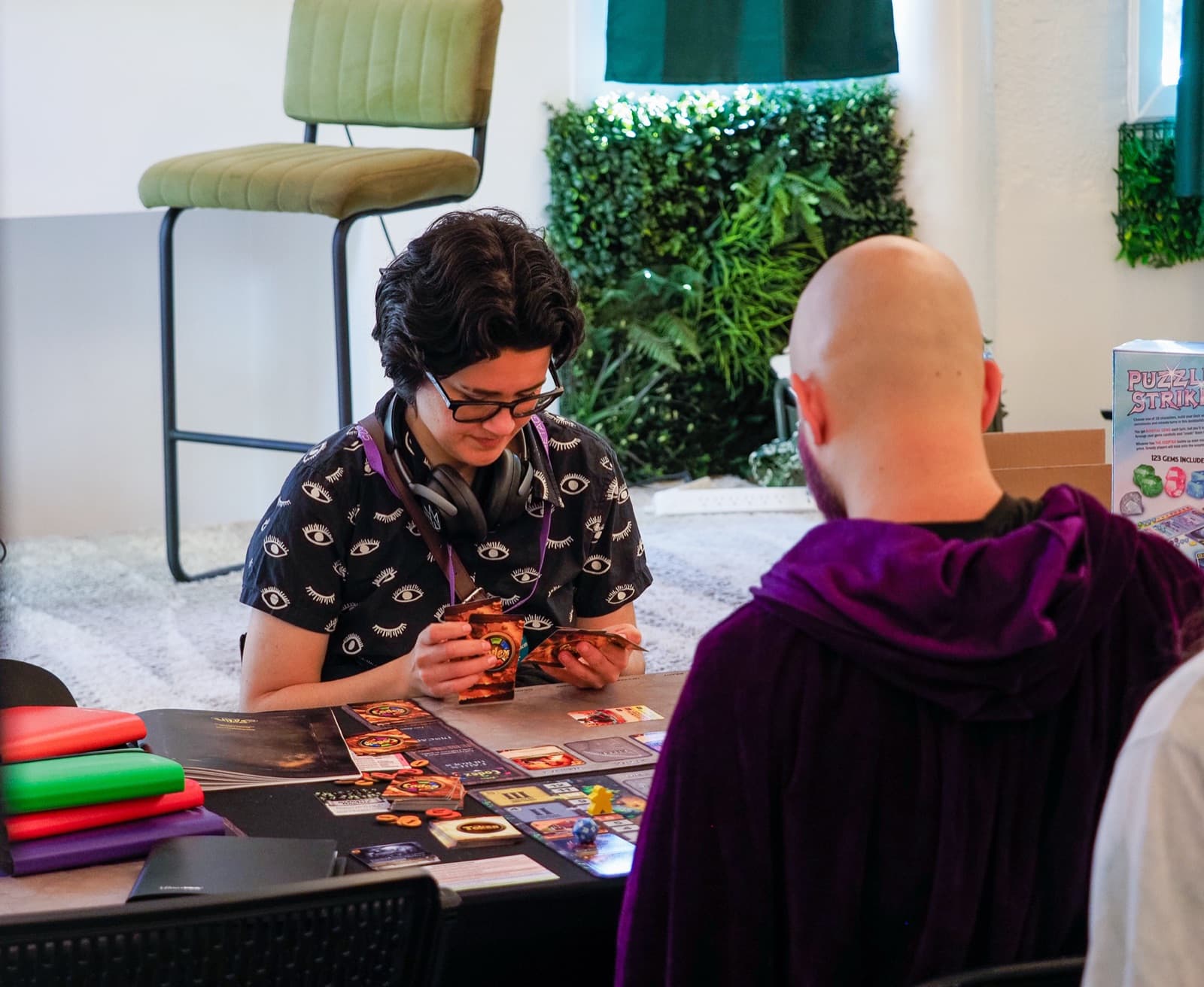 Two players studying their cards over a game of Codex
